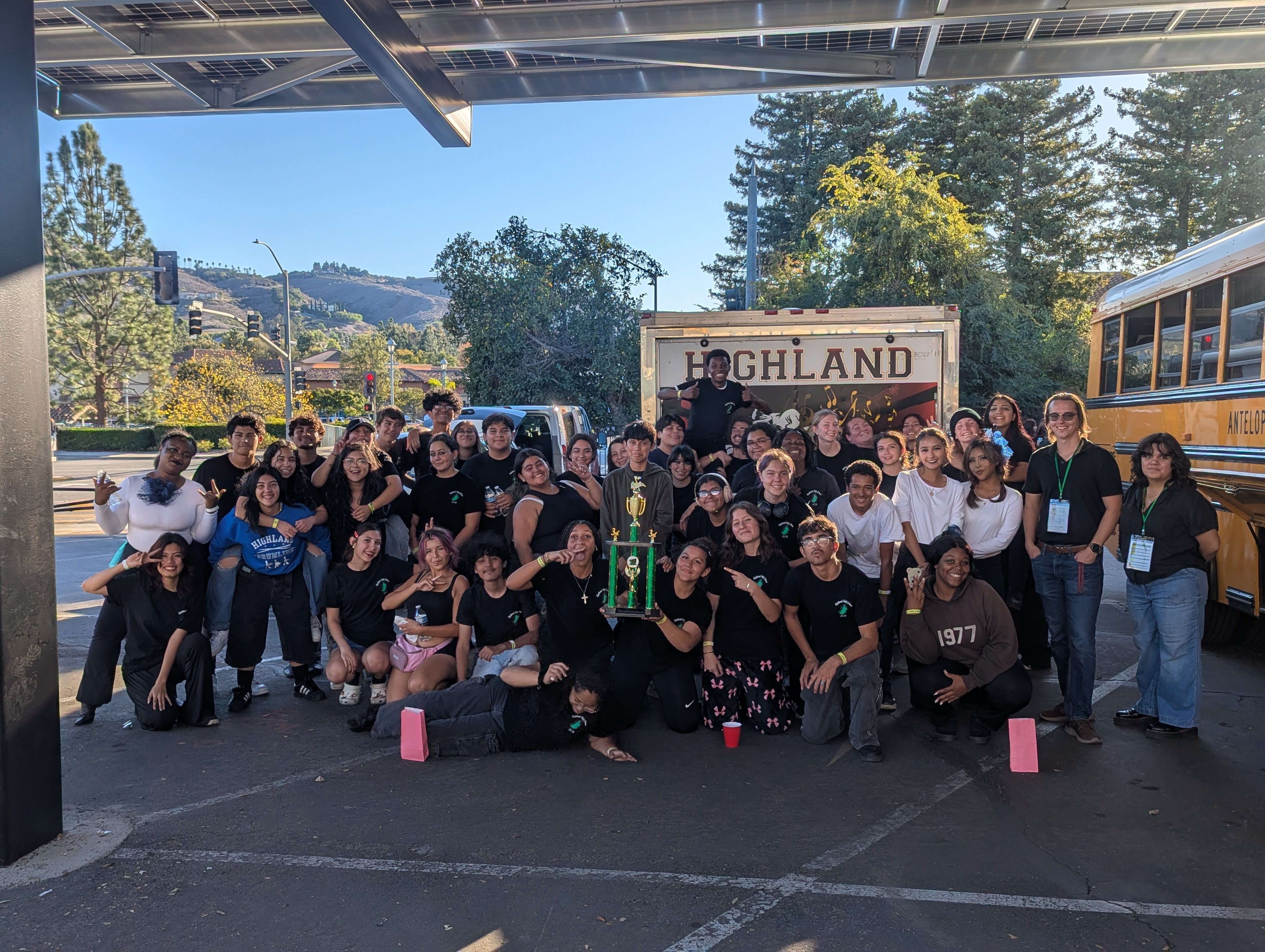HHS Band students celebrating with trophy after a competition